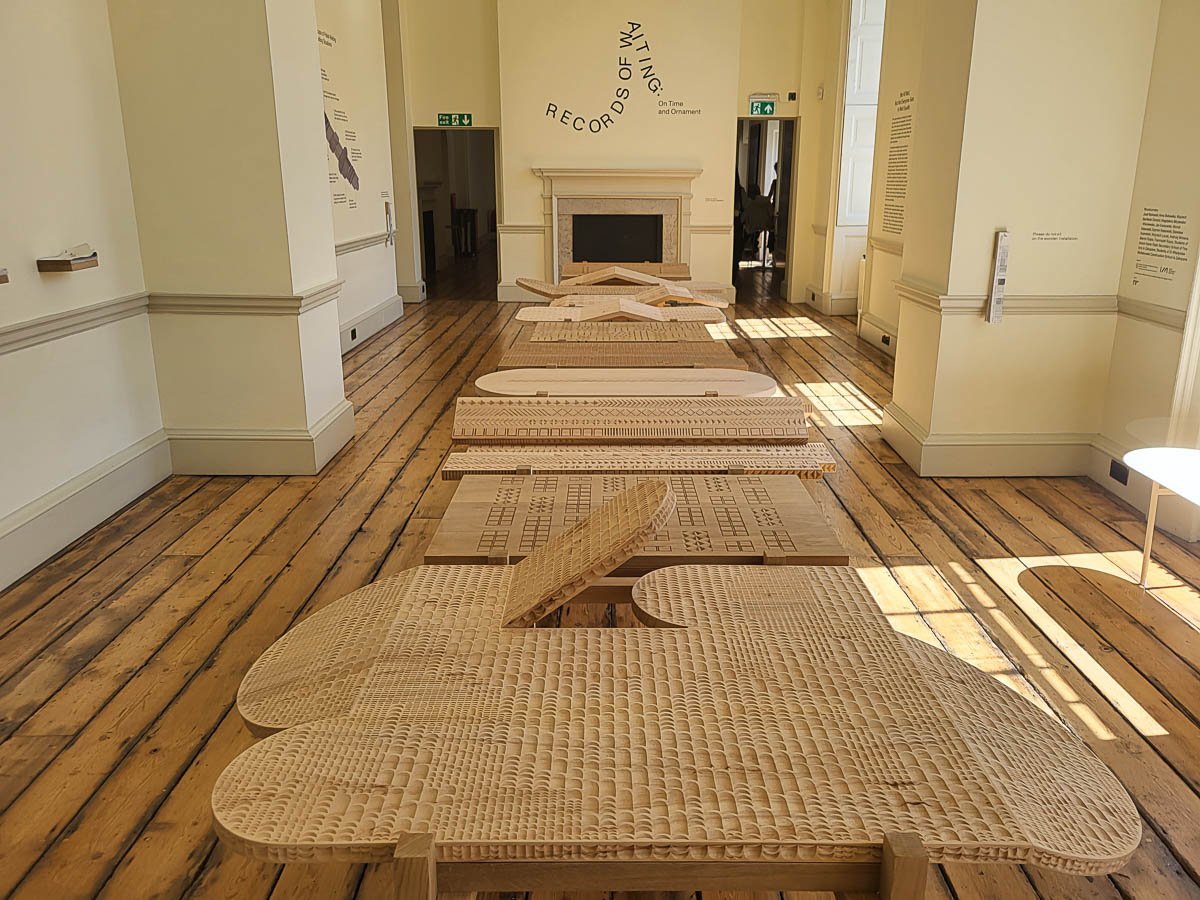 Paneles decorativos de madera que simbolizan distintas formas de espera, transformando lo ornamental en un registro con carga política y emocional.