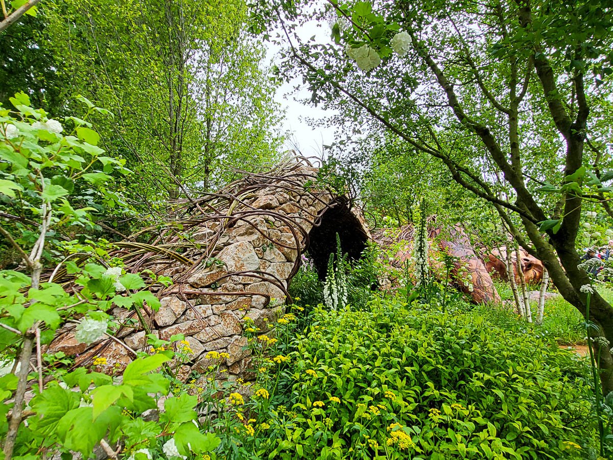 Jardín del Año de la RHS Chelsea. Un árbol caído esculpido con la figura de Gaia.